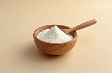 Isomalt powder in wooden bowl with spoon. Sweetener food additive E963, a sugar substitute disaccharide alcohol. Confectionery ingredient. Low-calorie alternative, used in bakery, confectionery.