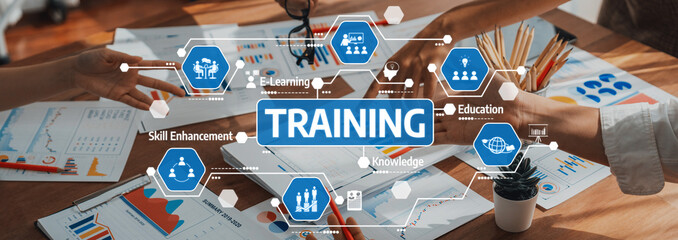 A collaborative office environment showcasing a training session focused on skill enhancement and e-learning, emphasizing teamwork through charts and educational materials. Amity