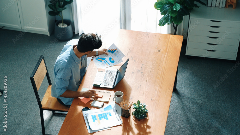 Poster skilled businessman writing idea on colorful sticky notes while looking at data analysis. caucasian 
