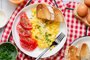 Scrambled eggs, tomatoes and toast for breakfast