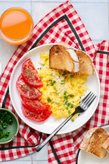 Scrambled eggs, tomatoes and toast for breakfast
