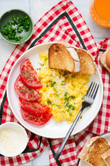 Scrambled eggs, tomatoes and toast for breakfast