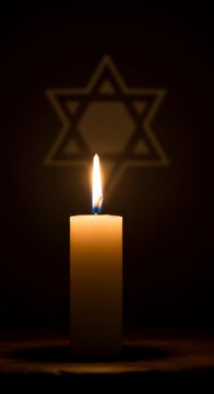 Candle flame with Star of David shadow for Holocaust Remembrance Day. Symbolic memorial image for Jewish history, persecution, and hope. Dark background with copy space.