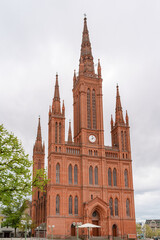 Fototapeta premium A large red Market church in Wiesbaden with a clock on the front