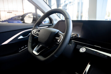 A close-up of a modern car's steering wheel with control buttons
