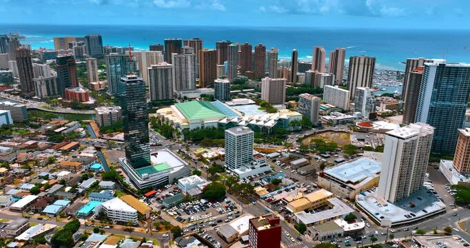 Lively modern Honolulu, Hawaii on beautiful sunny day. Aerial perspective on the city approaching downtown.