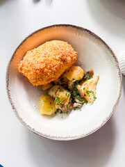 Kiev style chicken cutlet served with mashed potatoes and mushrooms