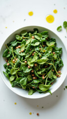 A fresh green leafy salad on a white surface with olive oil drizzled over top.