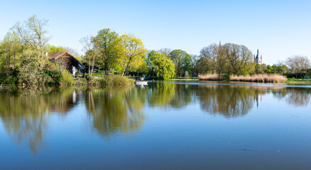 Fototapeta premium Tree reflections in the historical fortfication canal or Vesten in Ieper, West Flanders, Belgium