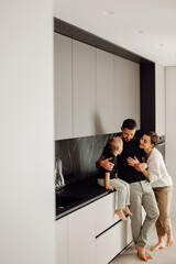 Happy family embracing in modern kitchen: sharing a tender moment
