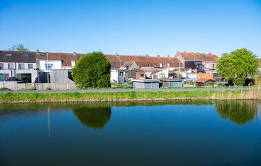 Obraz premium Colorful reflections of residential houses in the Comines - Ypres canal in Ieper, West Flanders, Belgium