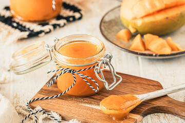 Homemade mango jam on white wooden table