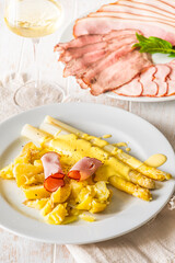 Plate with asparagus, potatoes, ham and hollandaise sauce