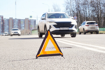 An emergency stop sign against the background of a road with cars. Providing timely warning of...