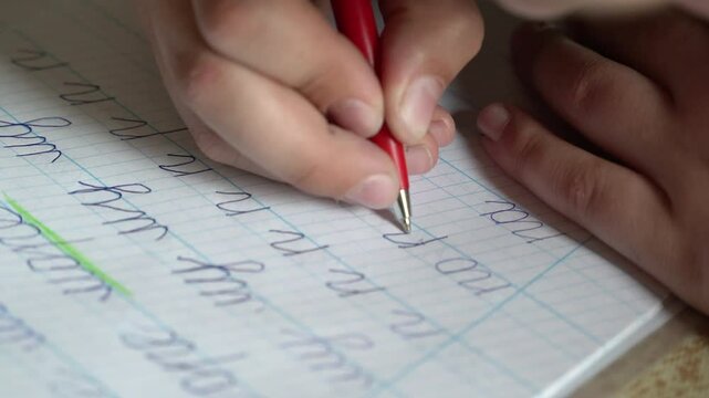 Child handwriting cursive letters on notebook