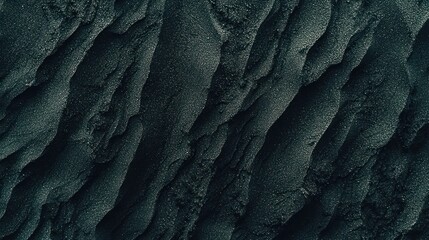 Dark volcanic sand ridges in a close-up texture shot