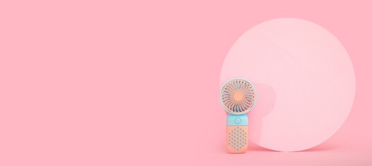 Mini electric fan on pink background with space for text
