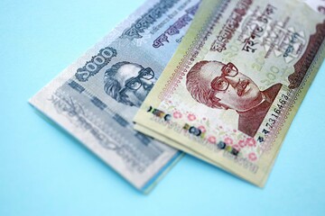 Bangladeshi taka money bills in big amount lies on teal color table close up