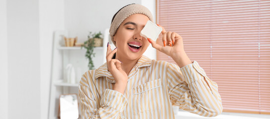 Happy young woman with soap in bathroom