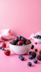 Bowl of berries on a pink background with blurred areas suggesting focus on the healthy food.
