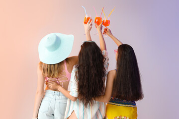 Young women with aperol spritz cocktail on light background, back view