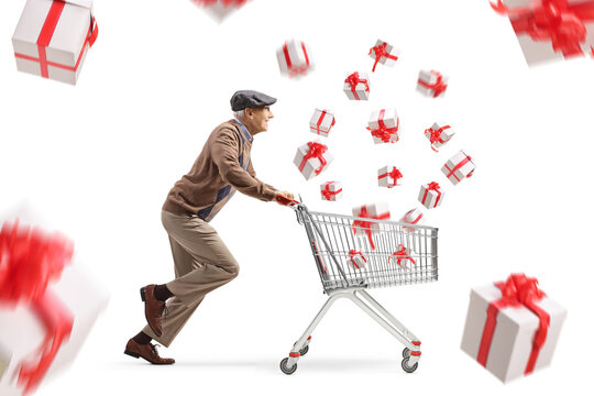 Senior man running and pushing a shopping cart with flaying presents