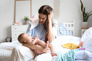 Stressed young mother suffering from postnatal depression at home