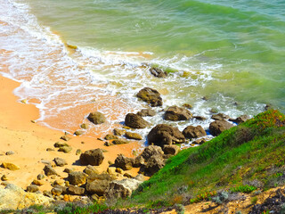 Sea surf at a typical Algarve beach with cliffs rocks and red sand