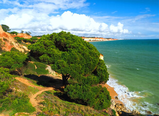 Algarve beach at Olhos de Agua with red cliffs at the coast of south Portugal