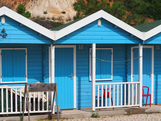 Blue wooden fishing huts or houses at the beach of Olhos de agua Algarve Portugal