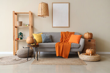Interior of cozy living room with sofa, shelf unit and autumn decor