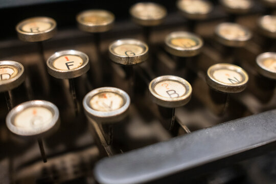 Close-up of vintage typewriter keys with a warm, nostalgic glow, capturing the essence of retro writing tools. Ideal for themes of history, creativity, or classic literature