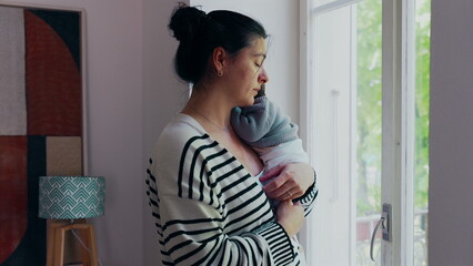 Mother standing by the window with newborn resting on her shoulder, gazing outside. scene conveys a sense of calm, connection, and the peaceful moments shared between mother and baby-SD 480p