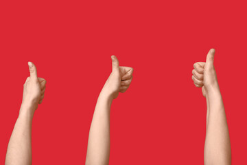 Female hands showing thumbs-up on red background