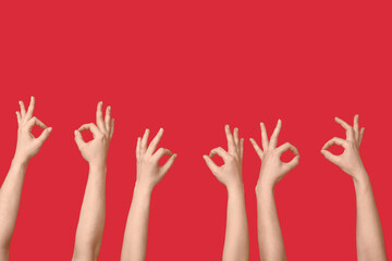 Female hands showing OK on red background