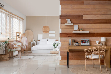 Interior of studio apartment with workplace and bed