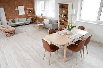 Interior of studio apartment with sofas, dining table and shelf units