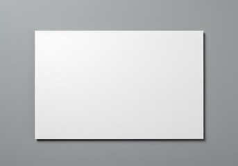 Rectangular white board mockup against a gray colored wall