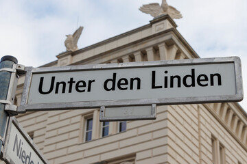 Fototapeta premium Street sign for Unter den Linden, located in Berlin, showcasing historical architecture. The sign is prominently displayed against a classic building, inviting exploration.