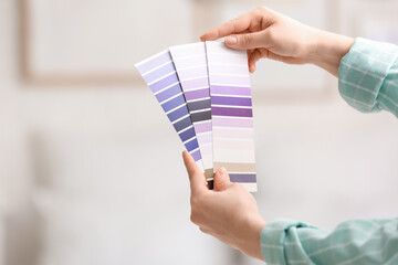Female hands with violet paint palette swatches at home, closeup