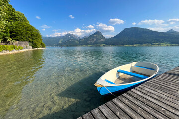 Wolfgangsee lake in Salzkammergut, Austria. Panoramic view. Pier and boats for recreation, fishing, sailing