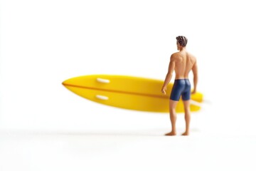 Miniature surfer figure with yellow surfboard, facing away from camera, on white background.