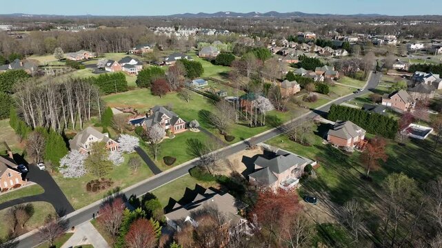 High class and high-end housing area in idyllic suburb of american town. Sunny day in spring season. Aerial wide shot. Luxury houses and mansion in Forest landscape in Virginia, USA.