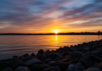 Vibrant Sunset Over Calm Lake with Rocky Shore