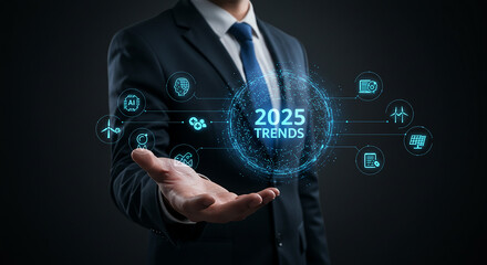 Businessman in a formal suit holding a glowing digital interface displaying 2025 TRENDS with futuristic data icons and networking symbols, representing business growth and market analysis