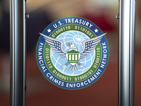 FinCen, US Treasury Financial Crimes Enforcement Network emblem, on a window FinCen logo, FinCEN agency front building.
