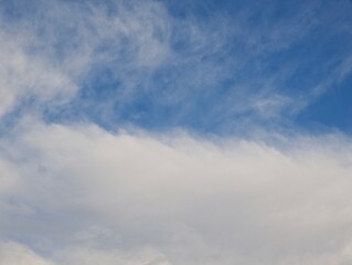 Wispy white clouds gently float across a deep blue sky, creating a serene and peaceful atmosphere