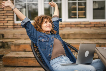 happy satisfied woman enjoy at garden after finish work on laptop