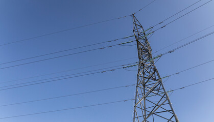 High voltage cables and transmission towers, isolated against a stunning sky