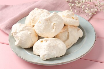 Delicious homemade meringue cookies on pink wooden table, closeup